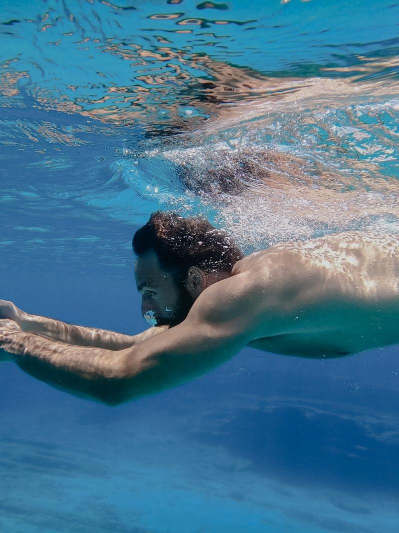A man swimming underwater in the sea 