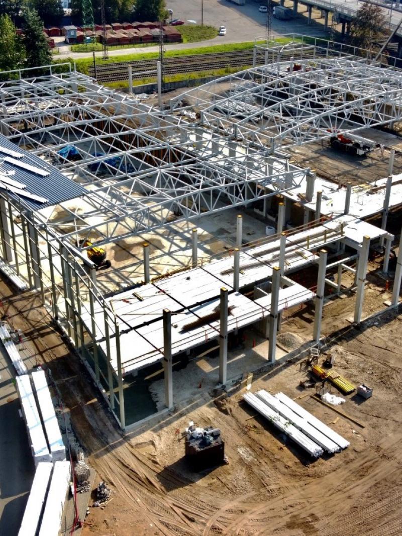 An aerial view of two arenas in construction next to a stadium