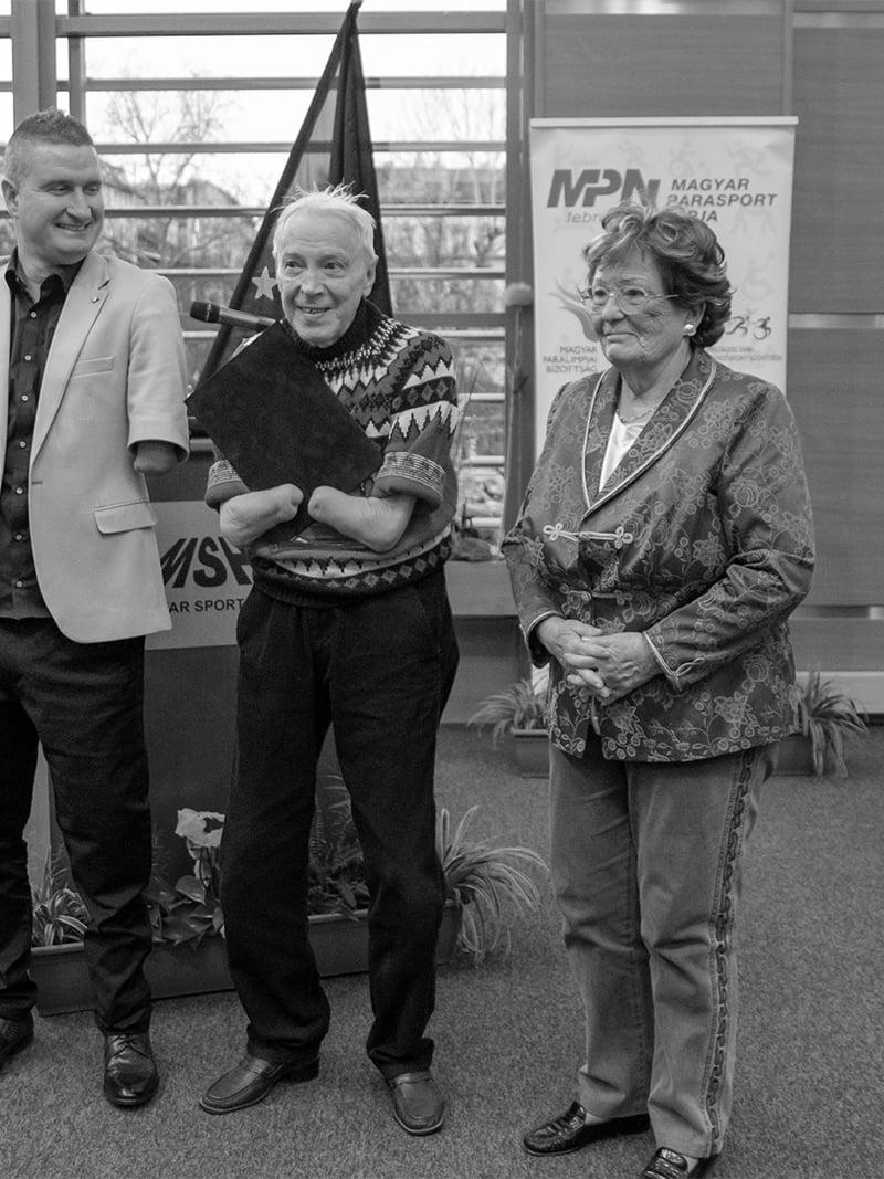 Black and white photo of elderly man without hands receiving an award 
