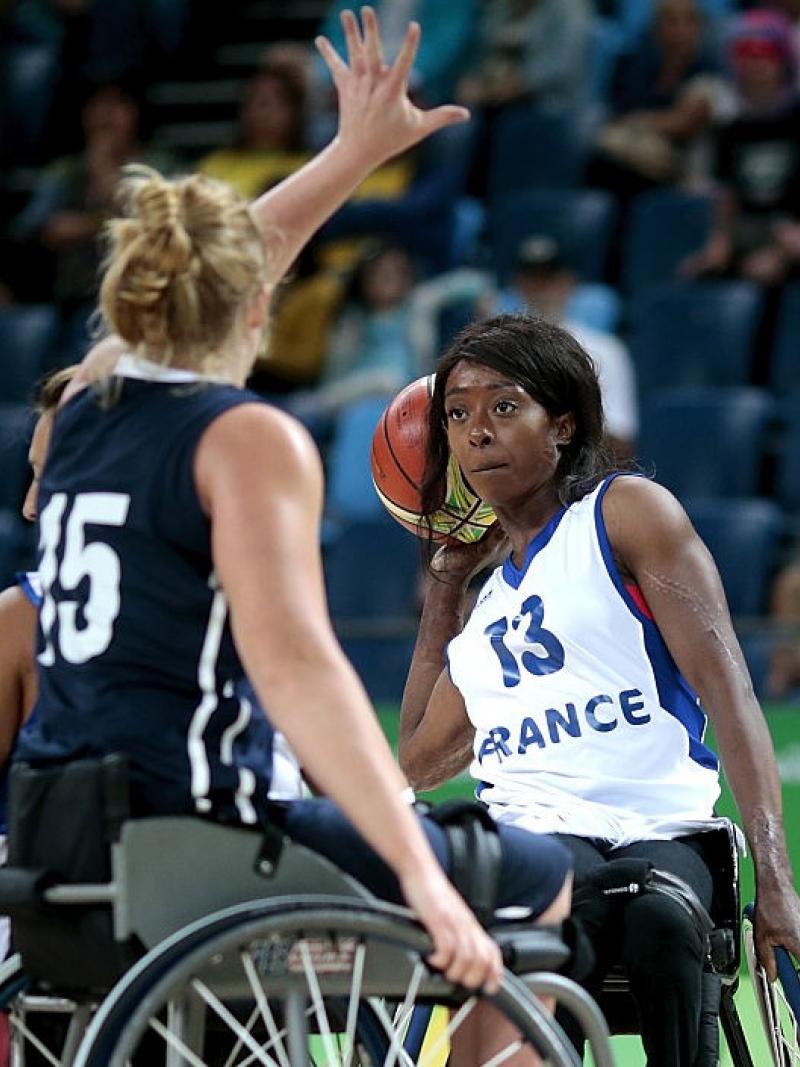 Female wheelchair basketball player defended strongly by her opponent