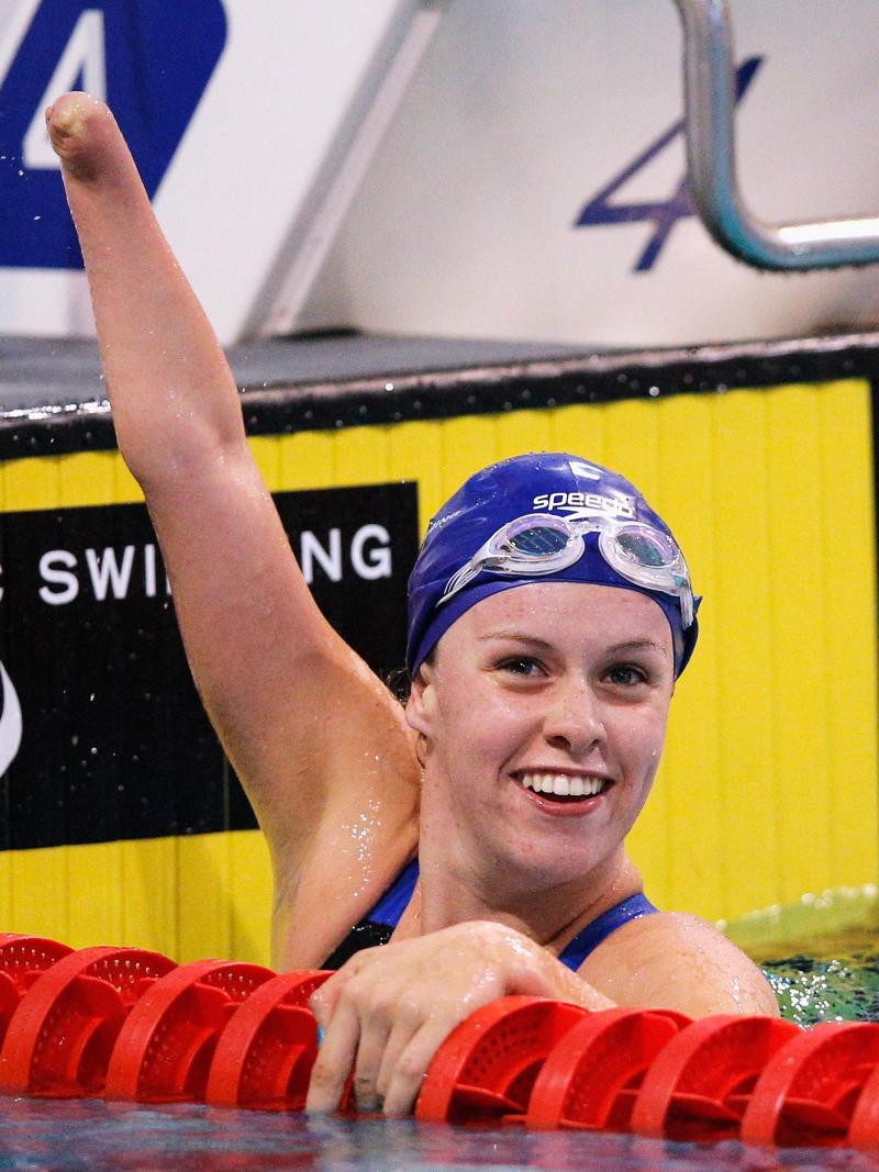 British swimmer Amy Marren lifts her arm and smiles while in the pool after a race