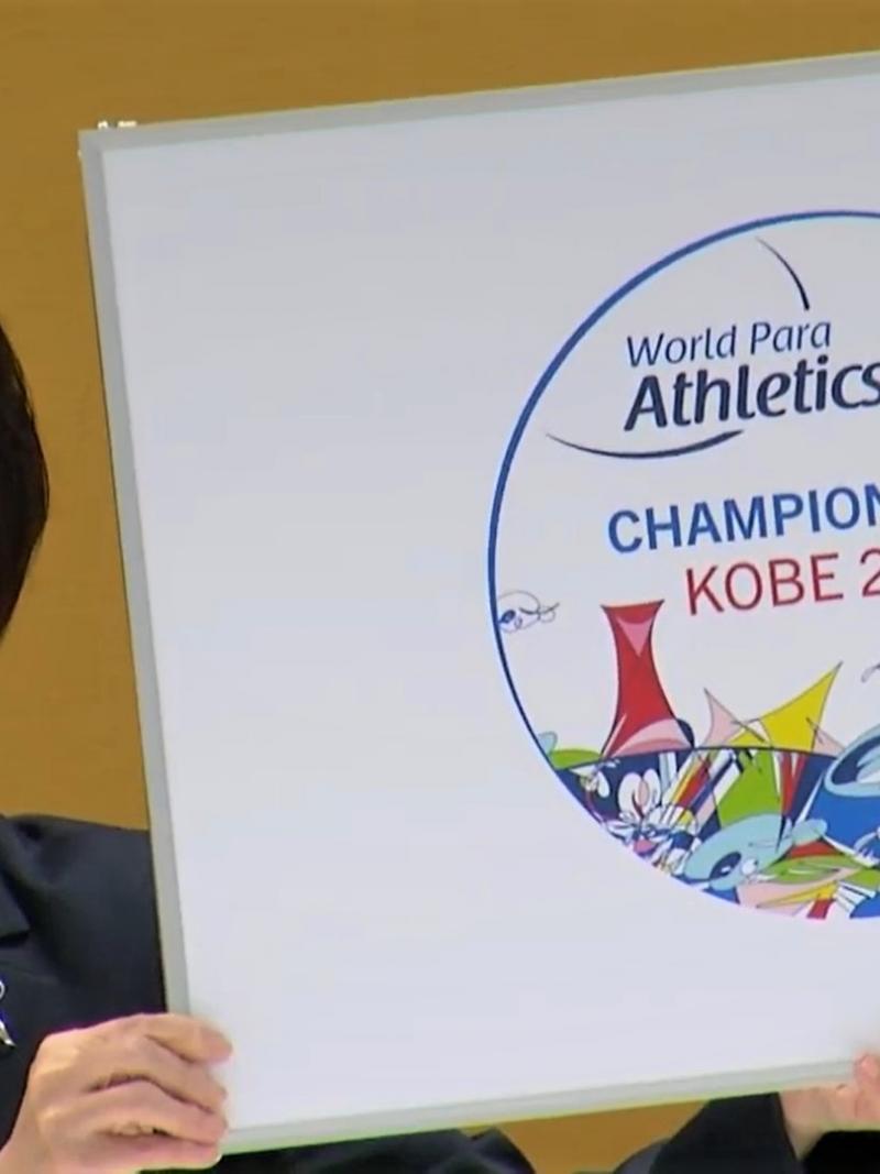 A Japanese woman holding a poster showing the logo of the Kobe 2022 World Para Athletics Championships