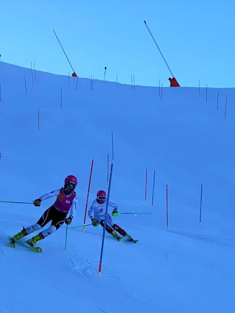 A vision impaired Para alpine skier following the guide in a slalom competition