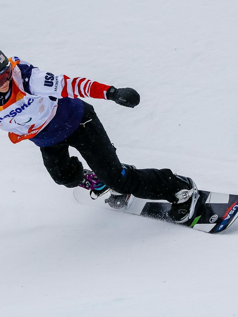 A female snowboarder with a prosthetic leg competing