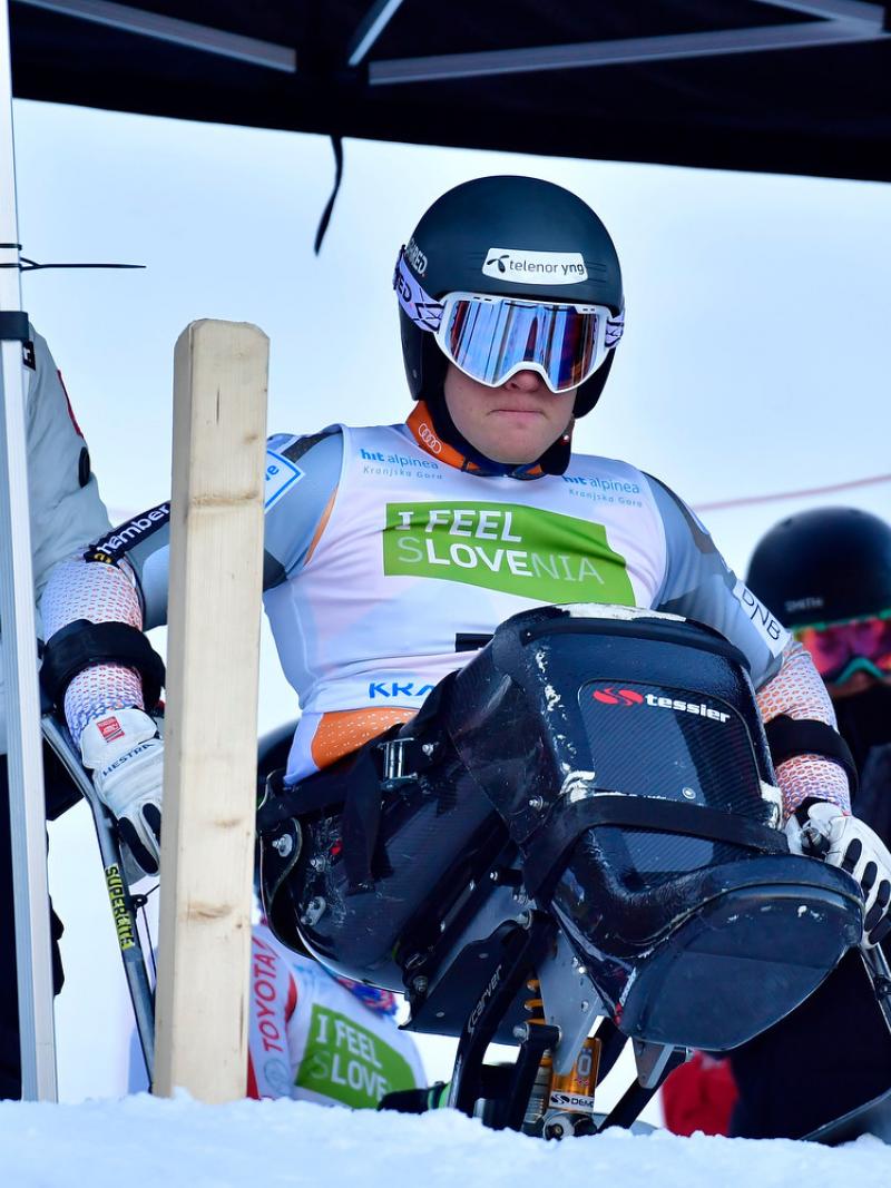 A woman observing a sit-skier at the starting gate