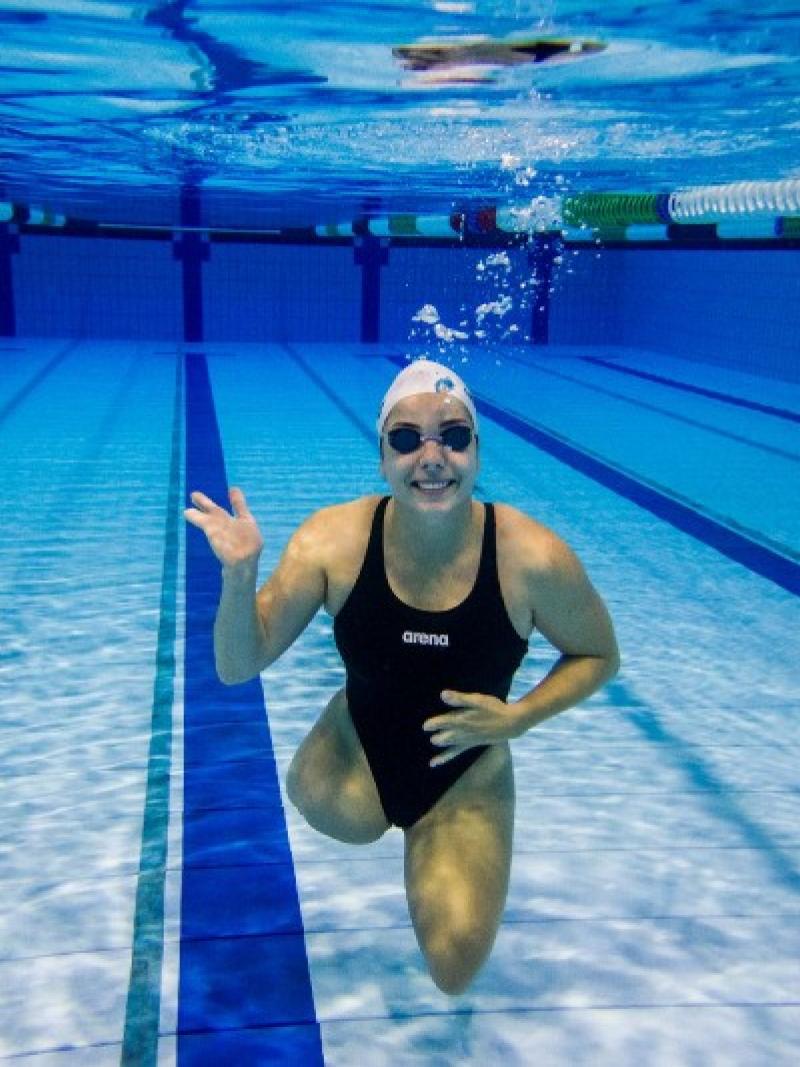 An underwater picture of a female swimmer without legs waving