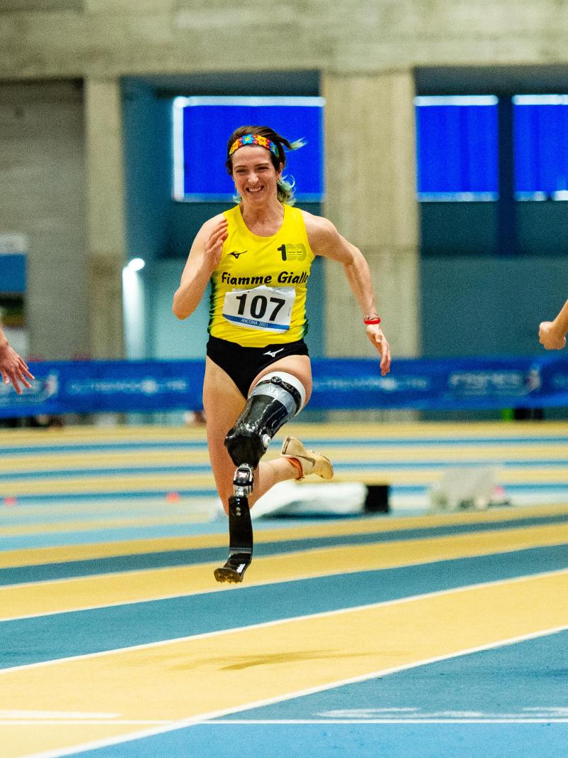 Three female blade runners in an indoor track