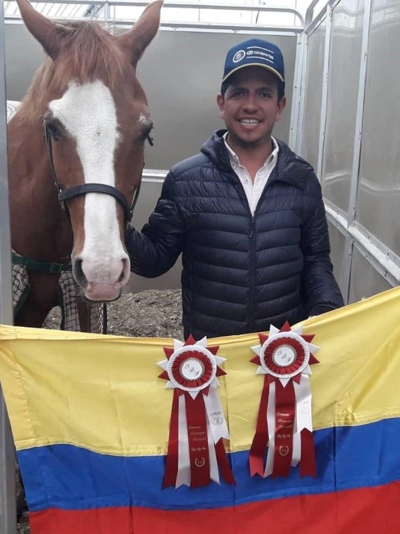 Man with his horse and a Colombian flag held in front of them