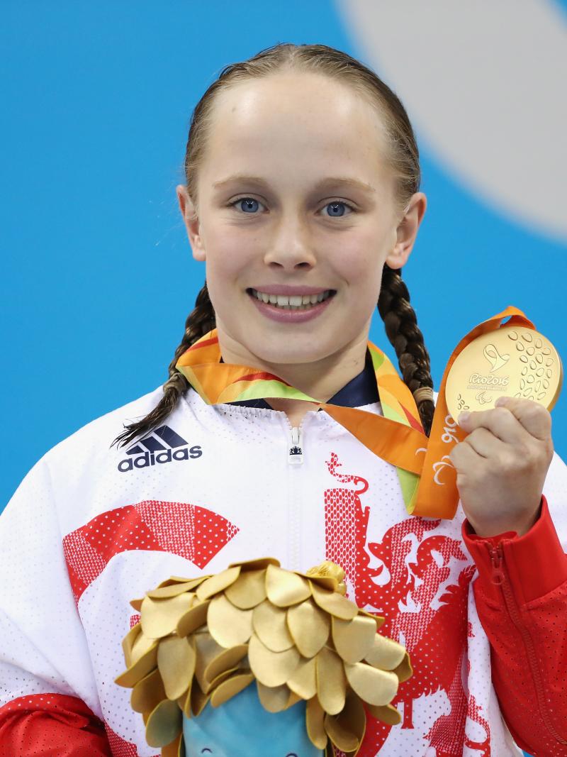 British female swimmer smiling with gold medal