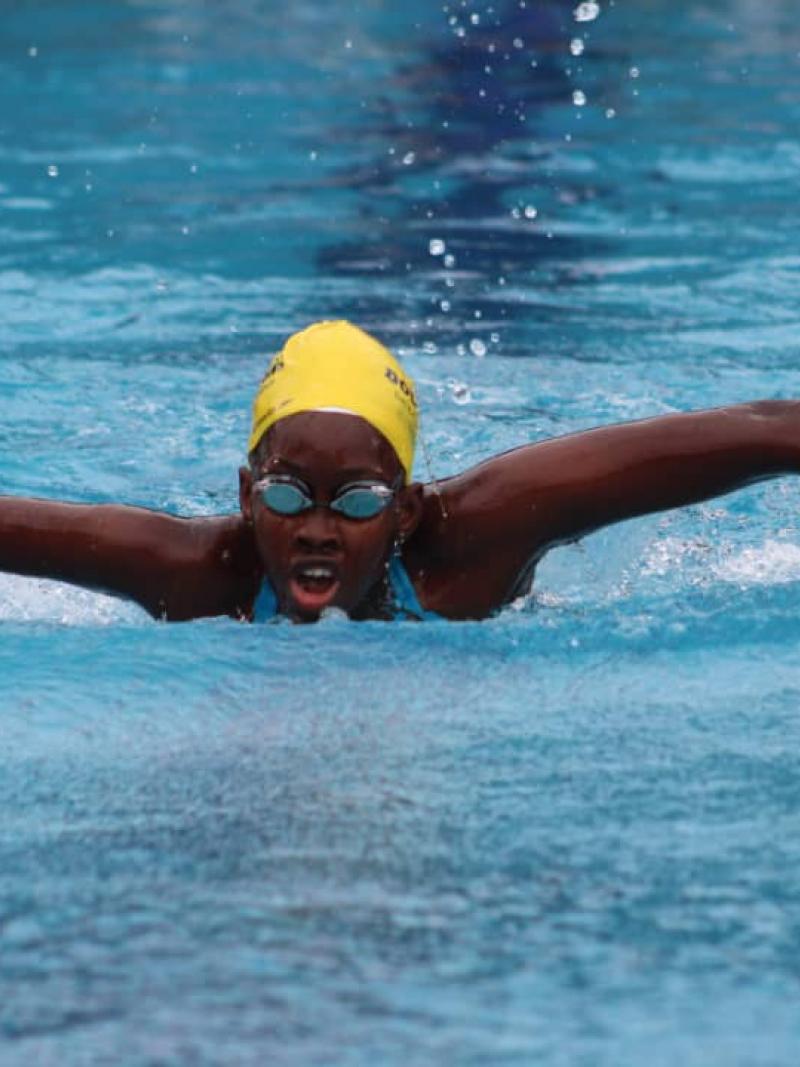Black female swimmer with missing forearm swimming