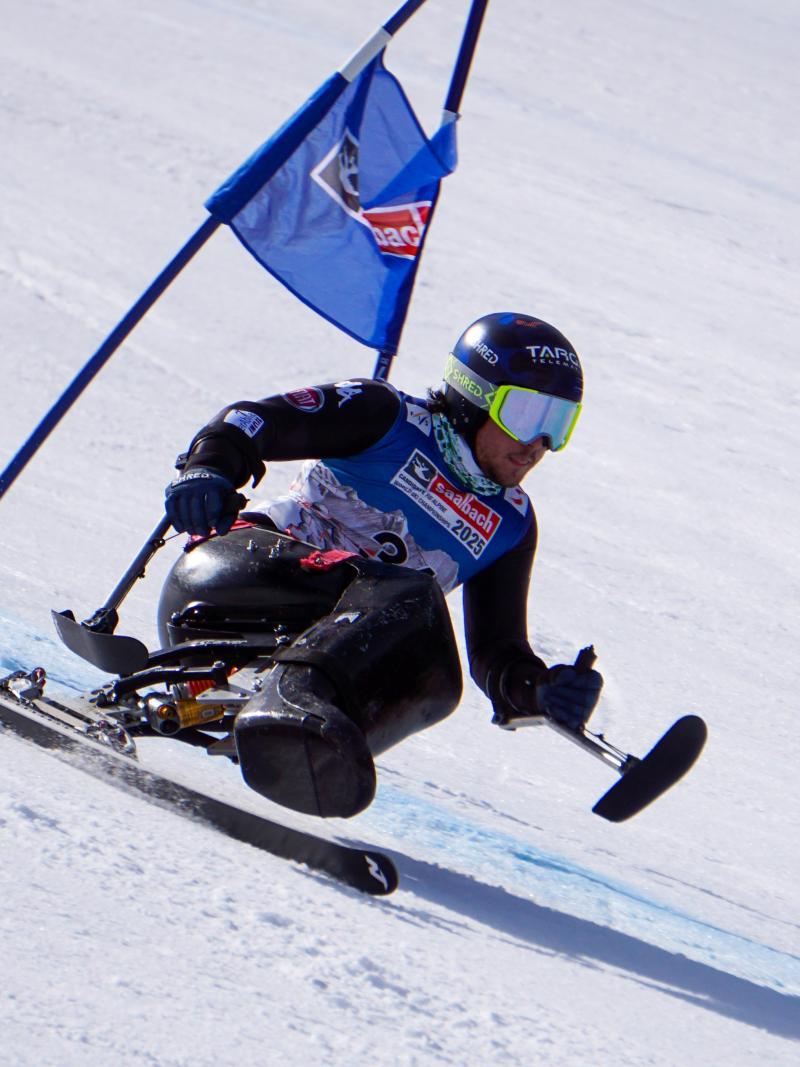 Male sit-skier makes a turn