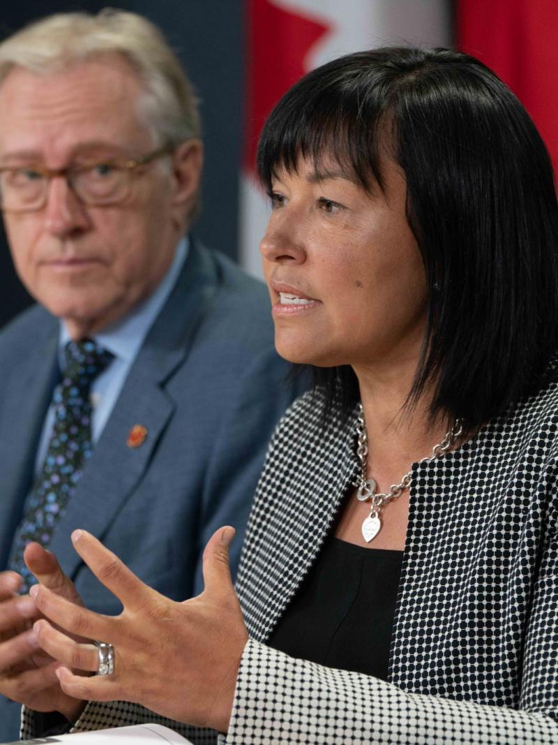 Chantal Petitclerc speaks with Canadian flag behind