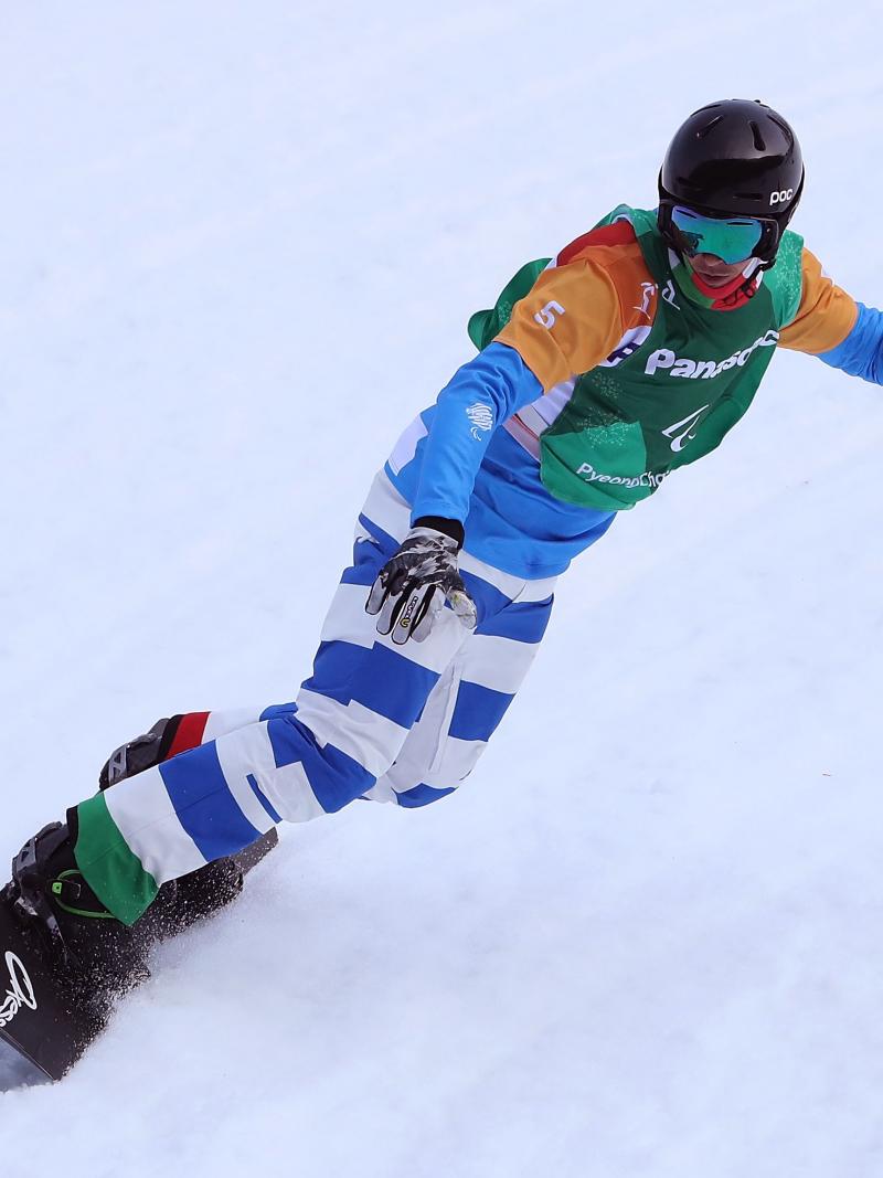 An one-armed man competing in a snowboard event 