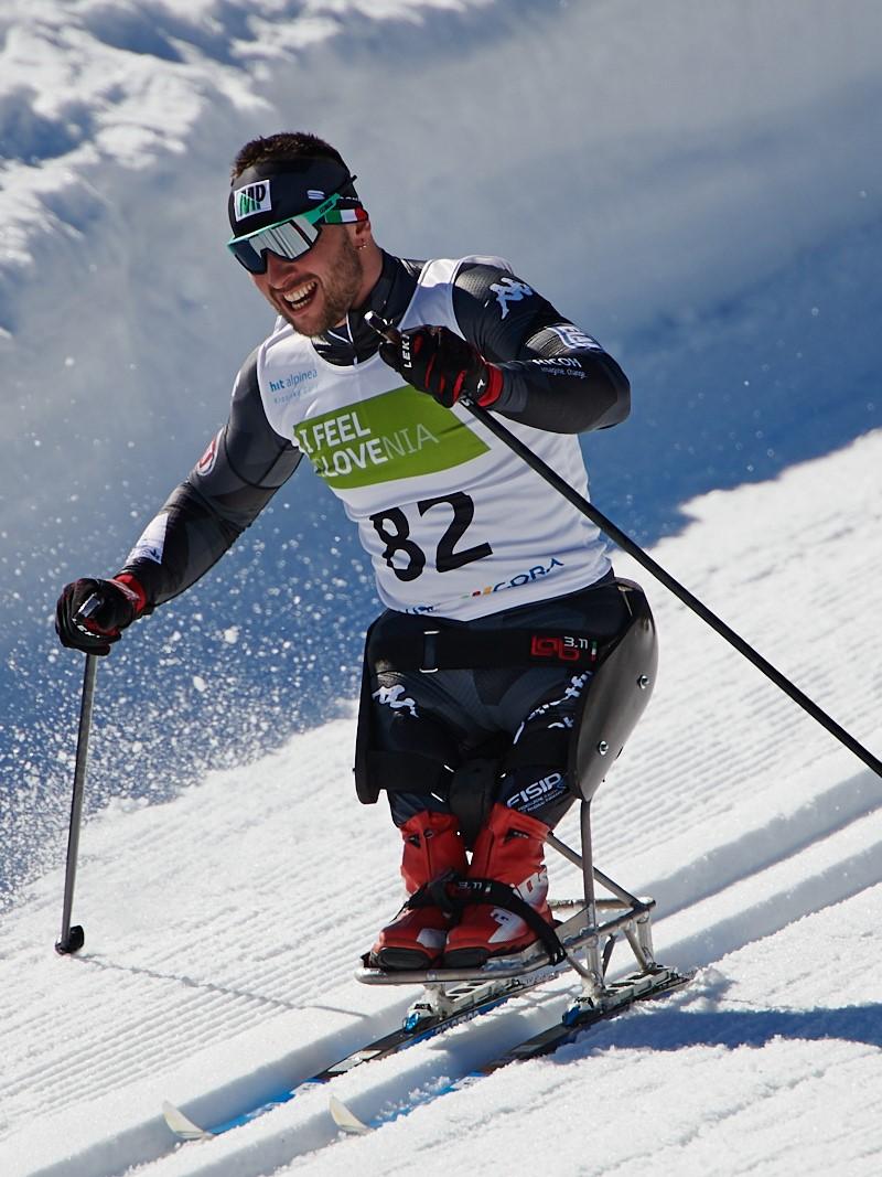 A man in a sit skiing competing in a cross-country event in the snow
