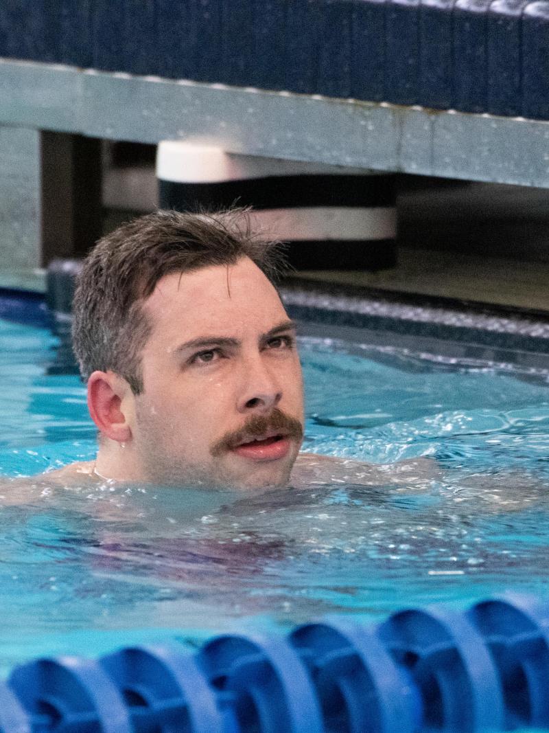 A male swimmer with a moustache in the swimming pool
