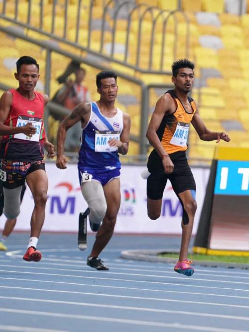 Three Asian men sprinting to the finish line