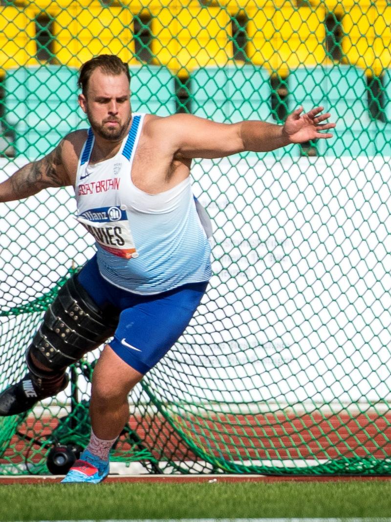 A man with a prosthetic leg competing in shot put