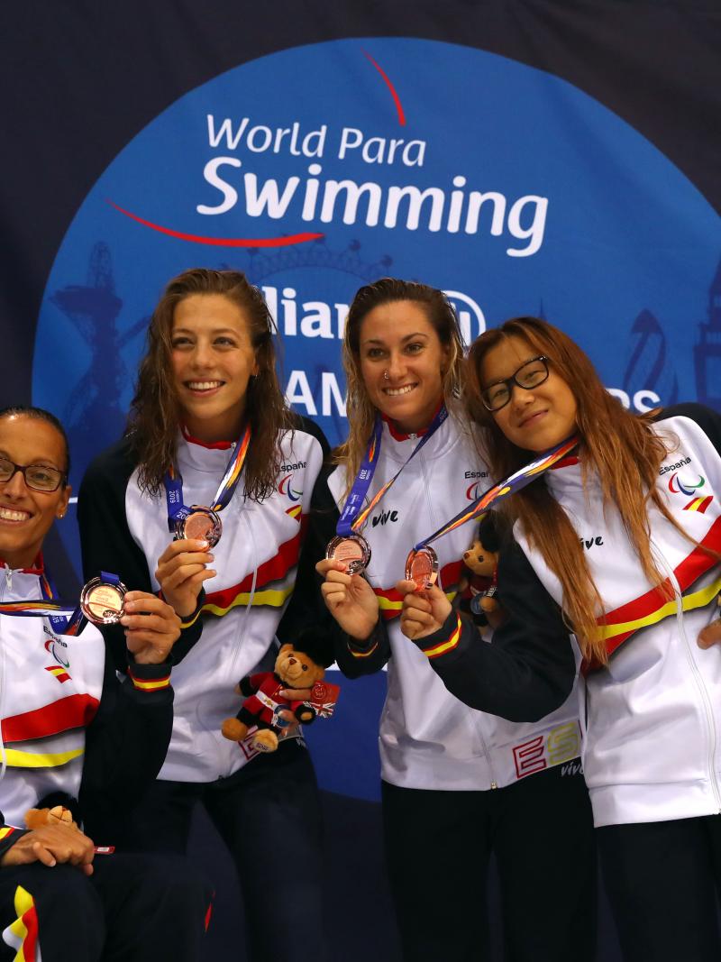 A group of four women with Spain's uniform showing their medals