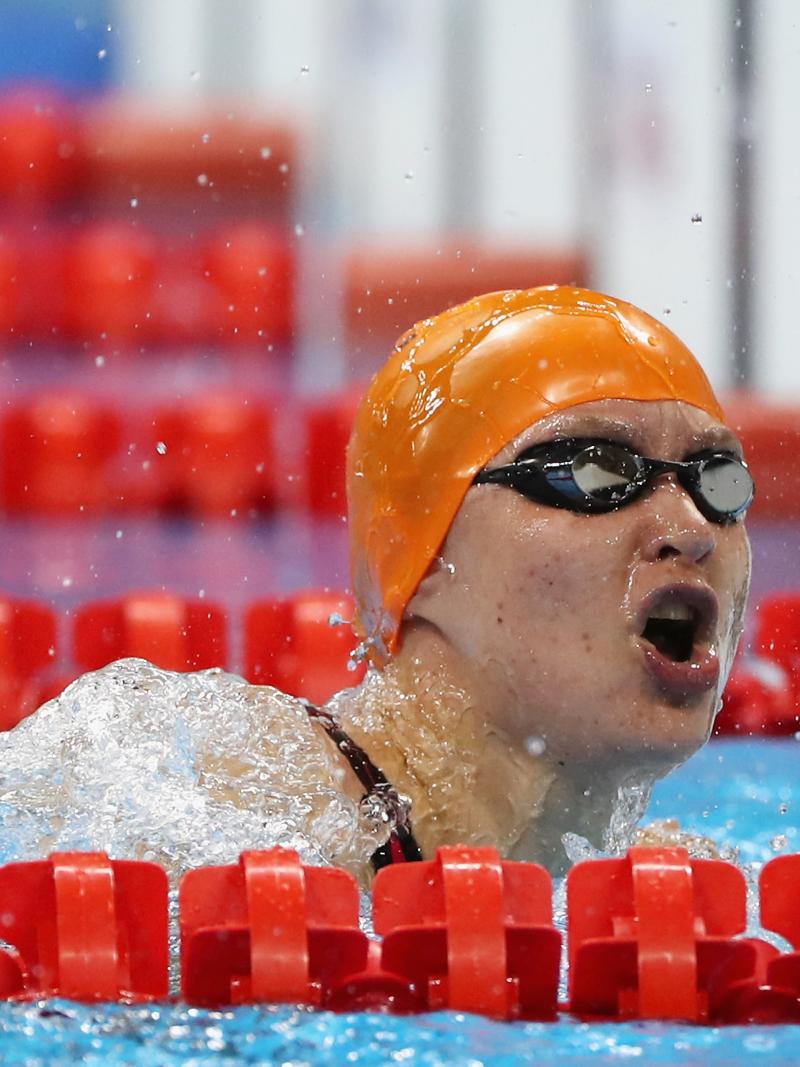 A female swimmer with orange cap in the water
