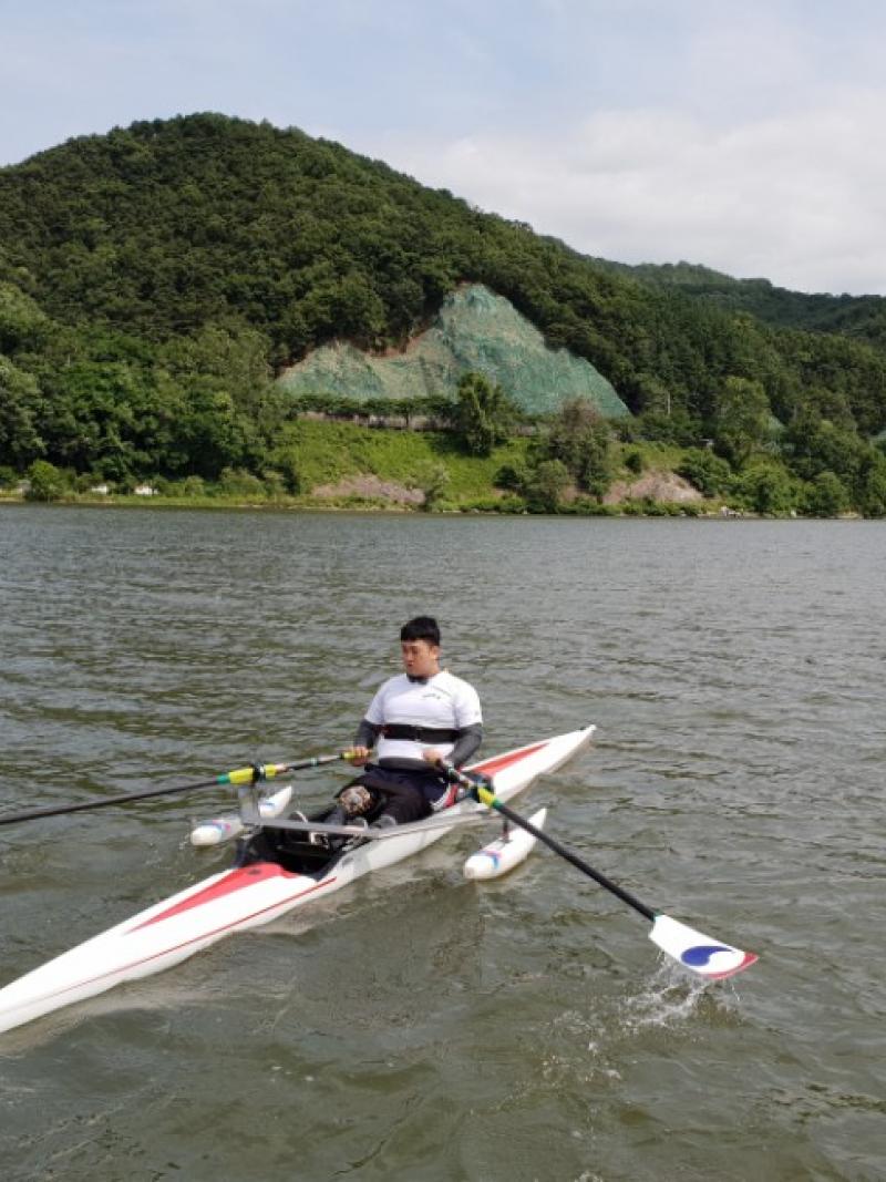 Man on rowing boat with scenic background