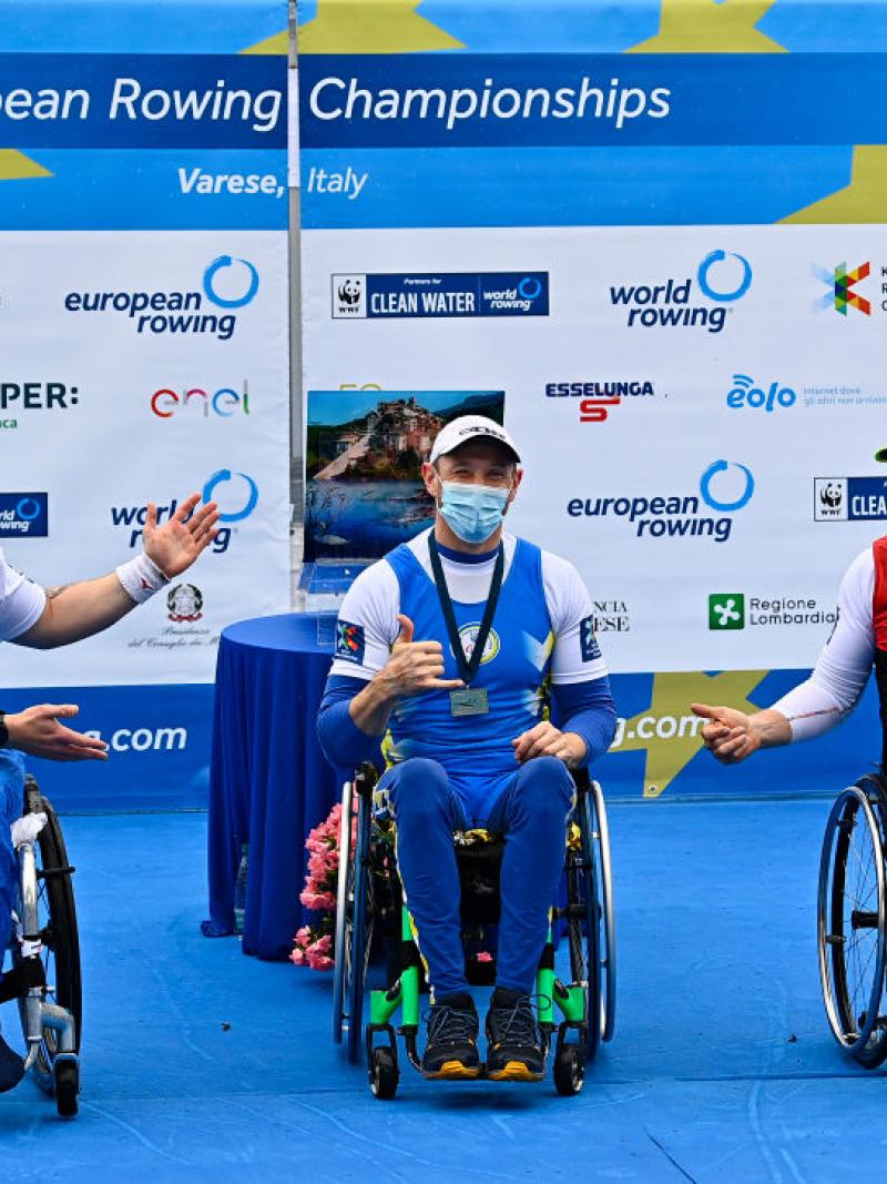 Three men in wheelchairs celebrating their medals