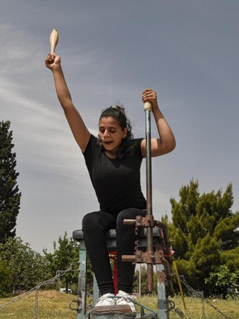 Para athlete on a chair throwing a club