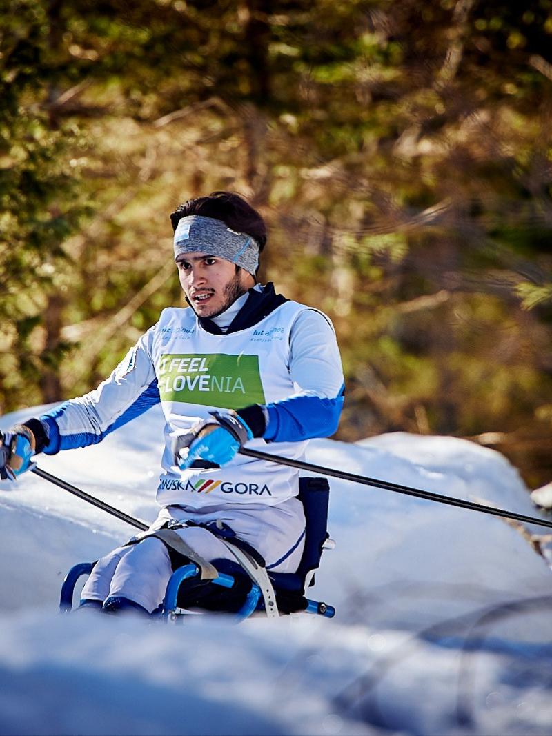 A male sit skier competing in a snowy cross-country skiing course