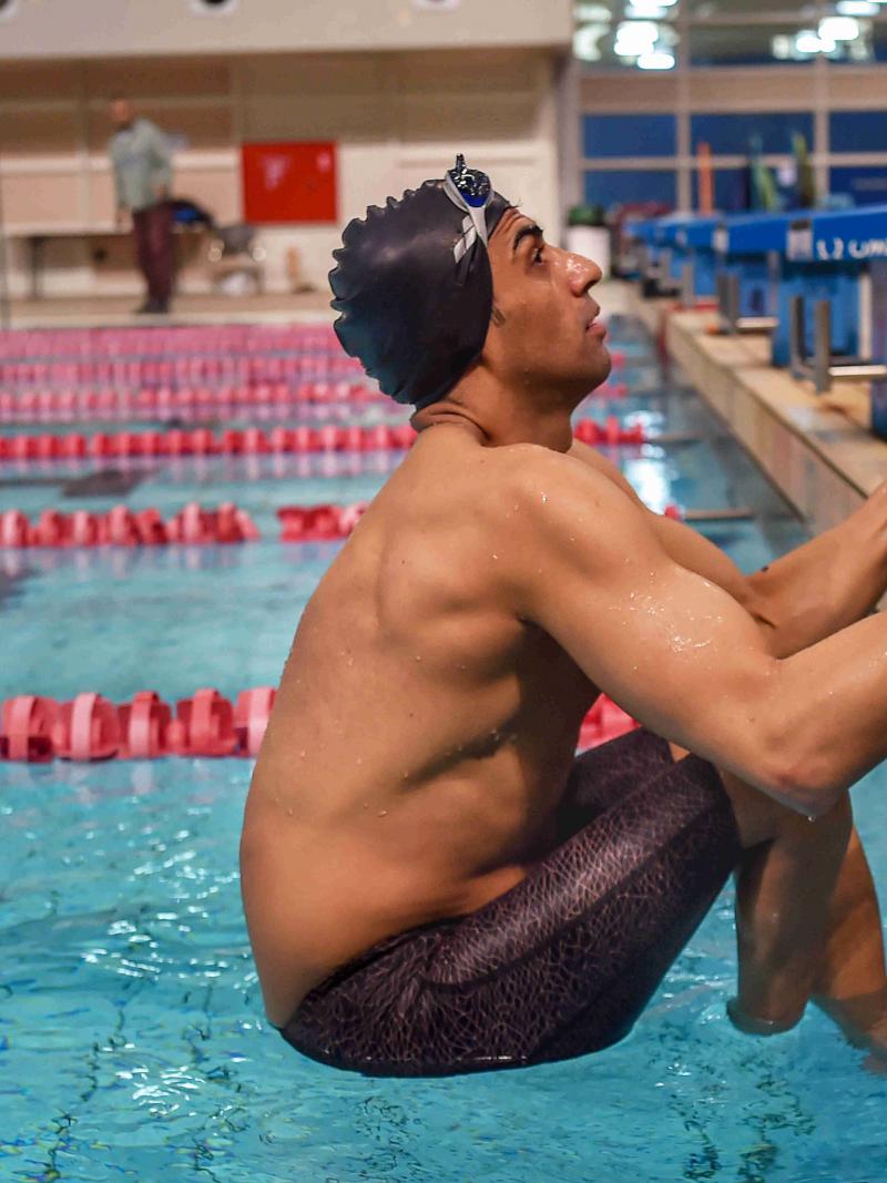 Male swimmer getting set on the blocks