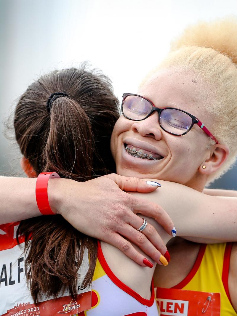 A woman with glasses hugging another woman