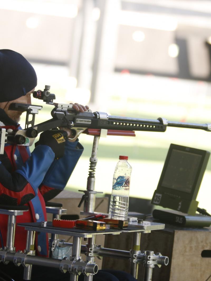 A man with a rifle competing in a shooting range