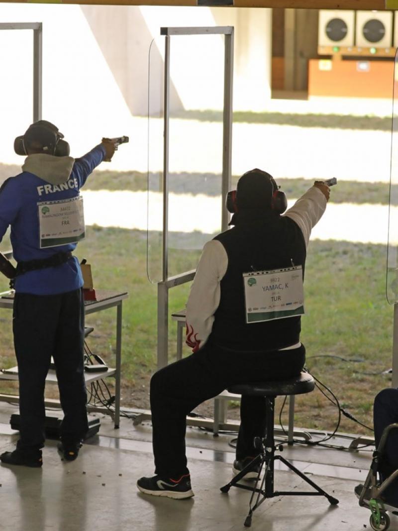 A group of four people competing with pistols in a shooting range