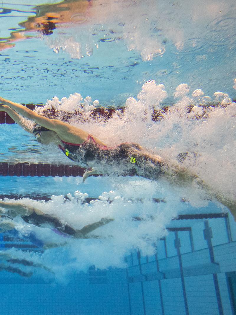 An underwater image of a female swimmer jumping in the water