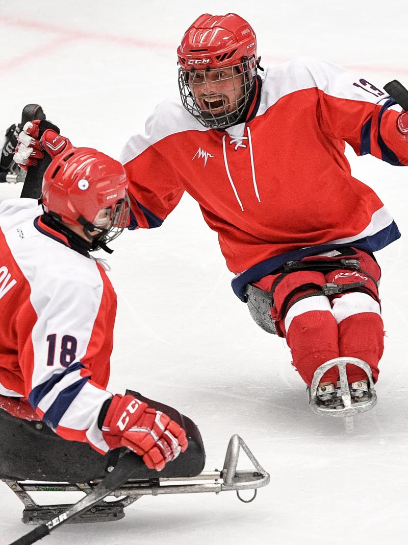 Two Para ice hockey players celebrating on ice