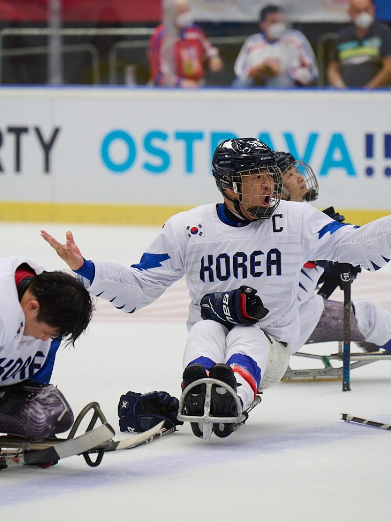 Three Para ice hockey players on ice with the uniform of South Korea