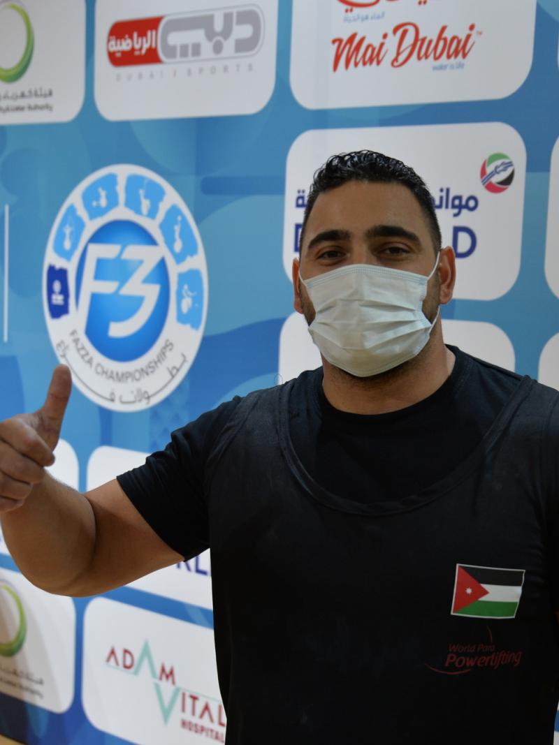A man with a face mask giving a thumbs up