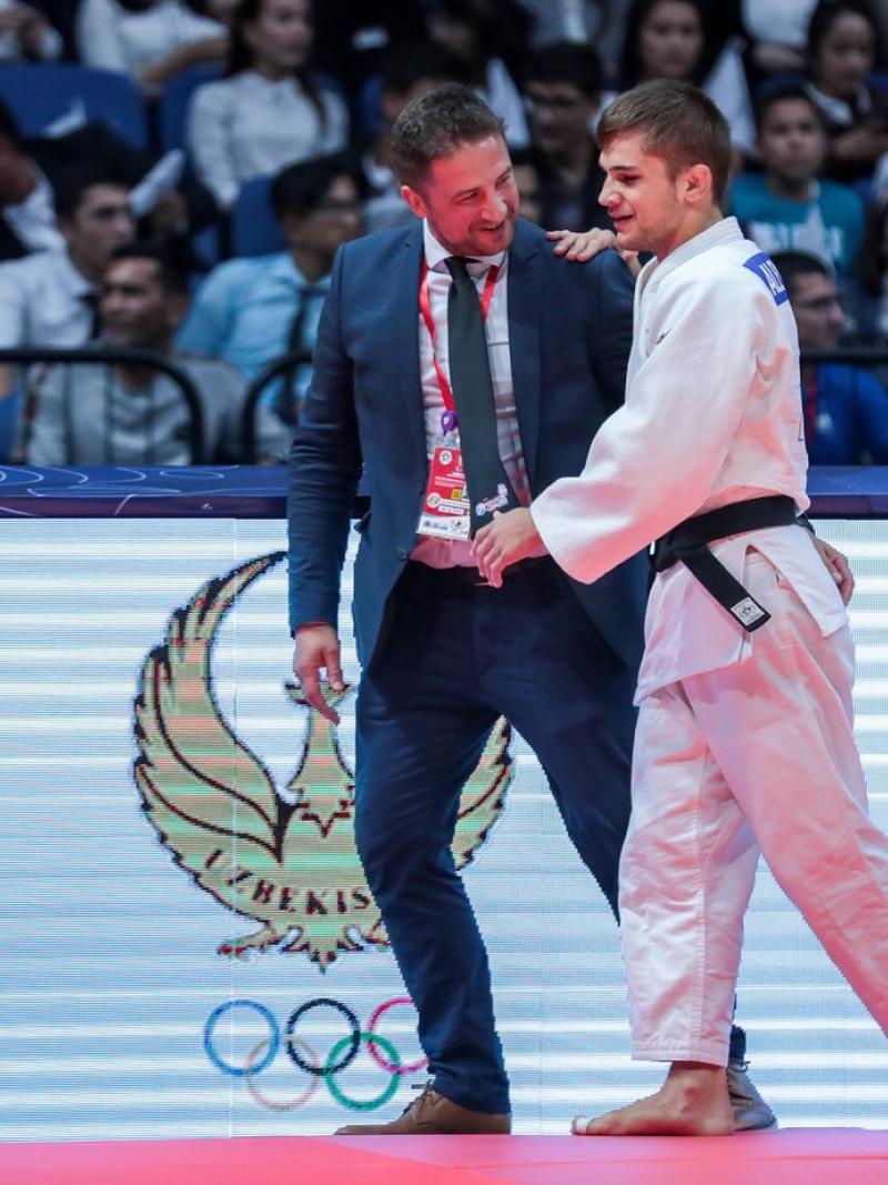 Judo coach guides blind judoka off the mat