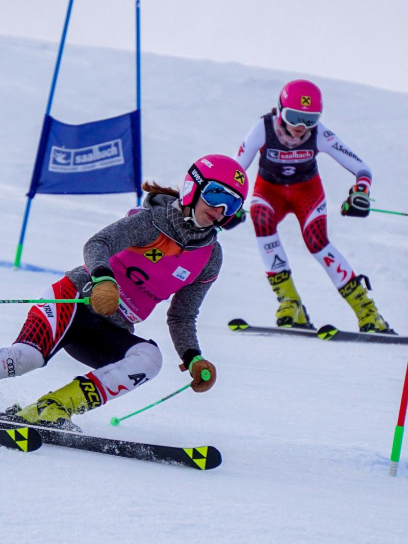 A female skier following her guide in a Para alpine skiing race