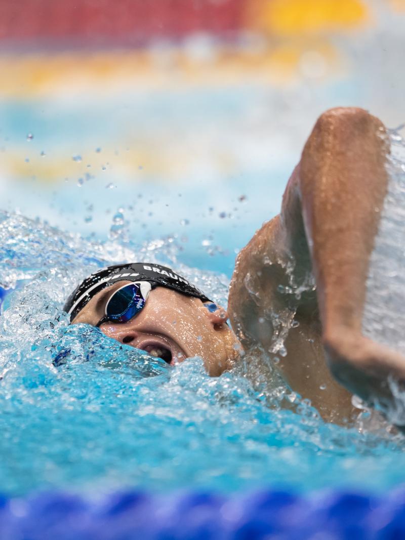 A man swimming freestyle in a pool