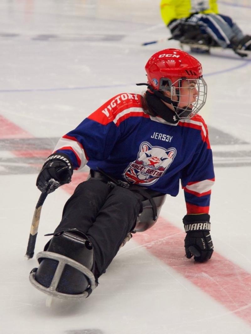 A female Para ice hockey player in a rink