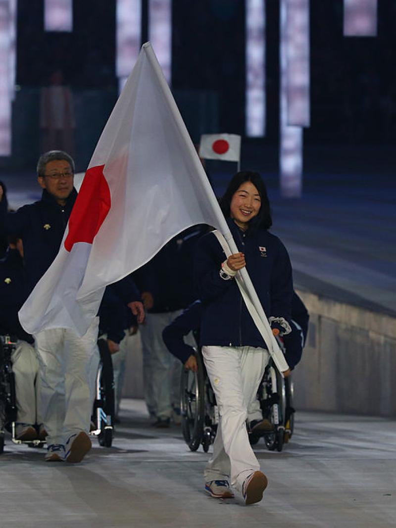 Japanese woman carries flag at Opening Ceremony