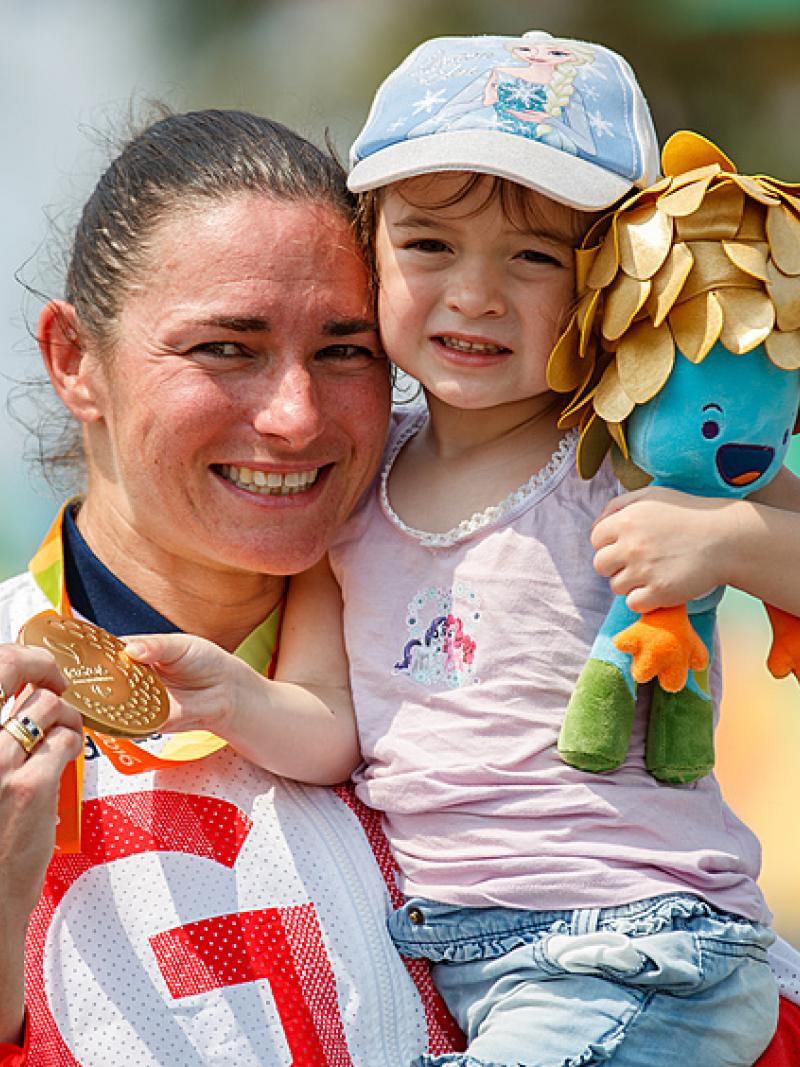 Sarah Storey cuddles her daughter and displays her gold medal