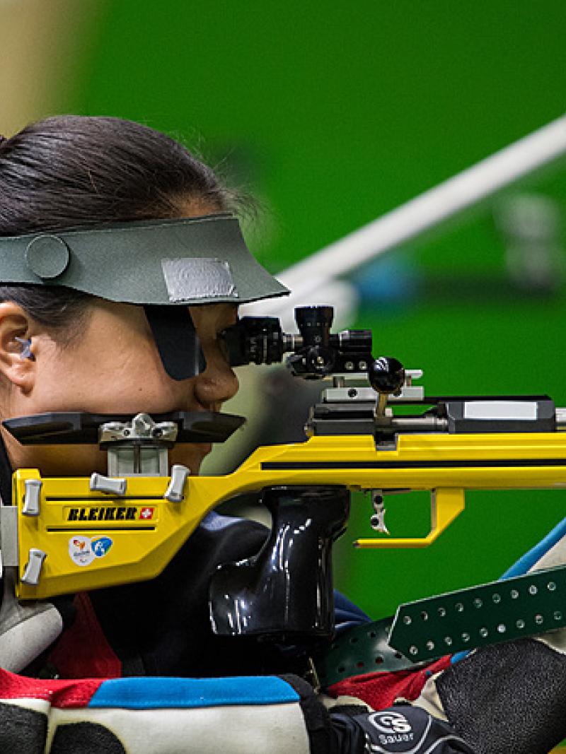 A woman shooting with a rifle in a competition