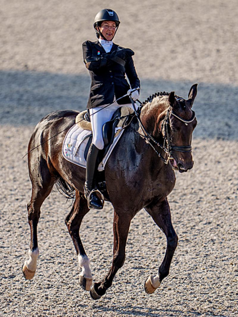 Philippa Johnson-Dwyer smiling riding her horse Just In Time