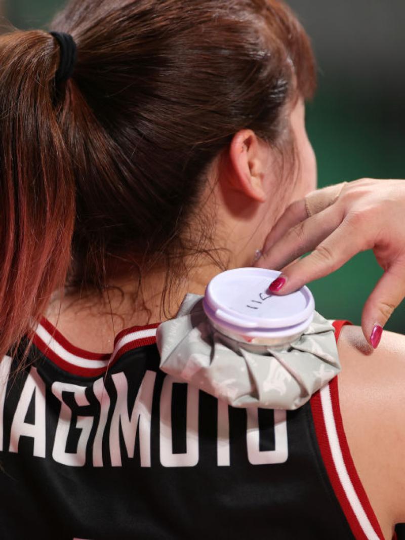 Woman puts ice pack on shoulders