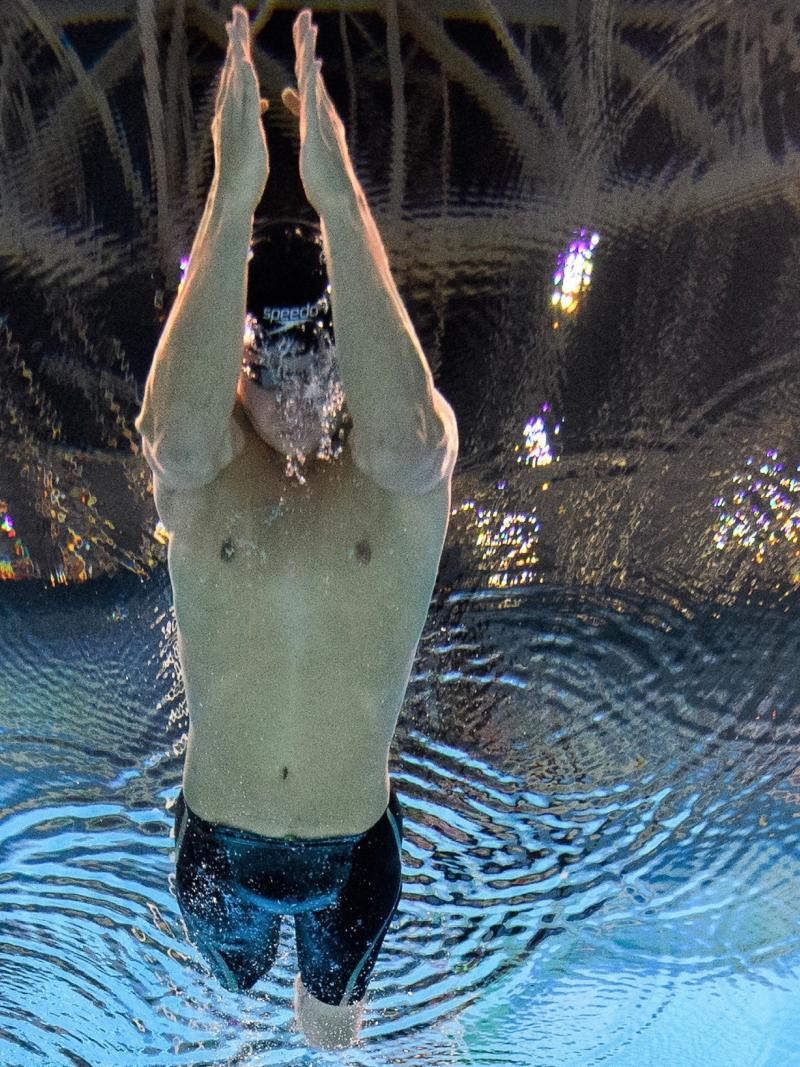 An underwater image of a man without legs swimming in a pool