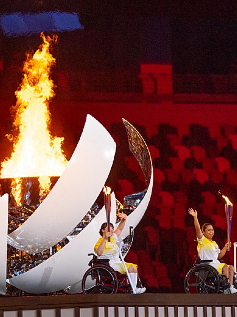 Japanese Para athletes Yui Kamiji, Shunsuke Uchida and Karin Morisaki turn and wave after lighting the Tokyo 2020 Paralympic Flame