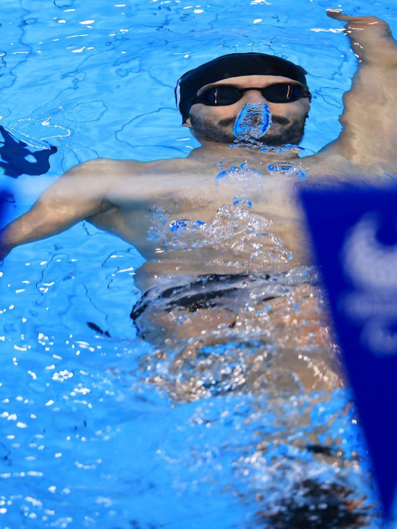 A man swimming backstroke underwater in a pool