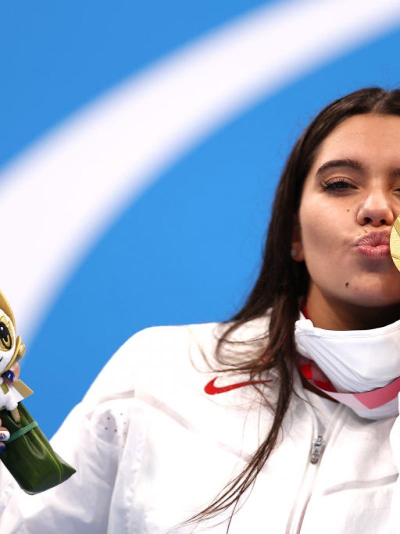 A young woman kissing her gold medal
