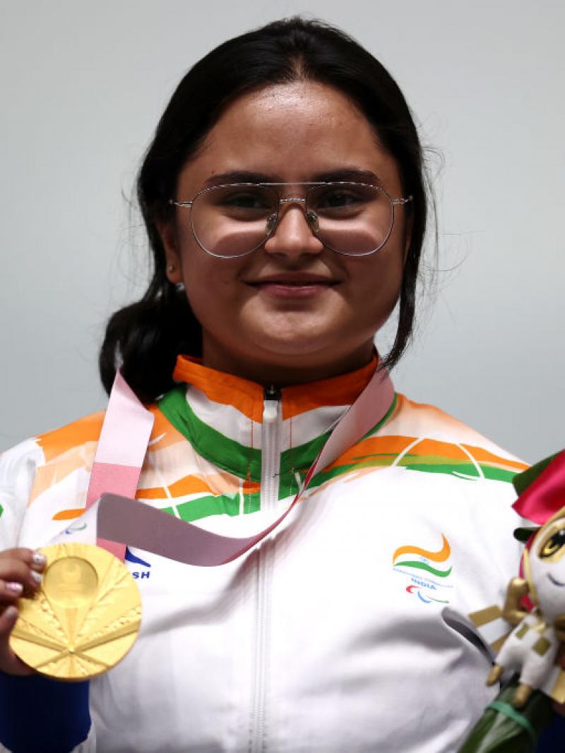 A young woman in the uniform of India posing with a gold medal