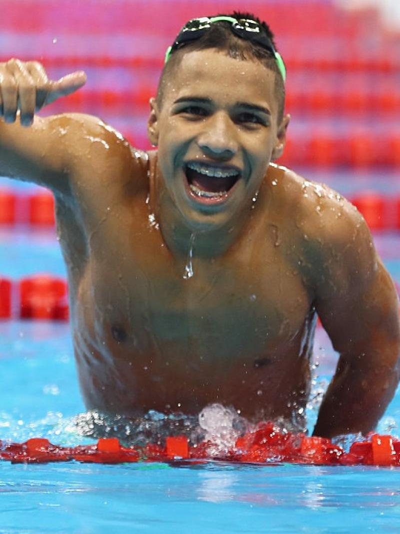 A man in the pool smiles with a thumbs up 